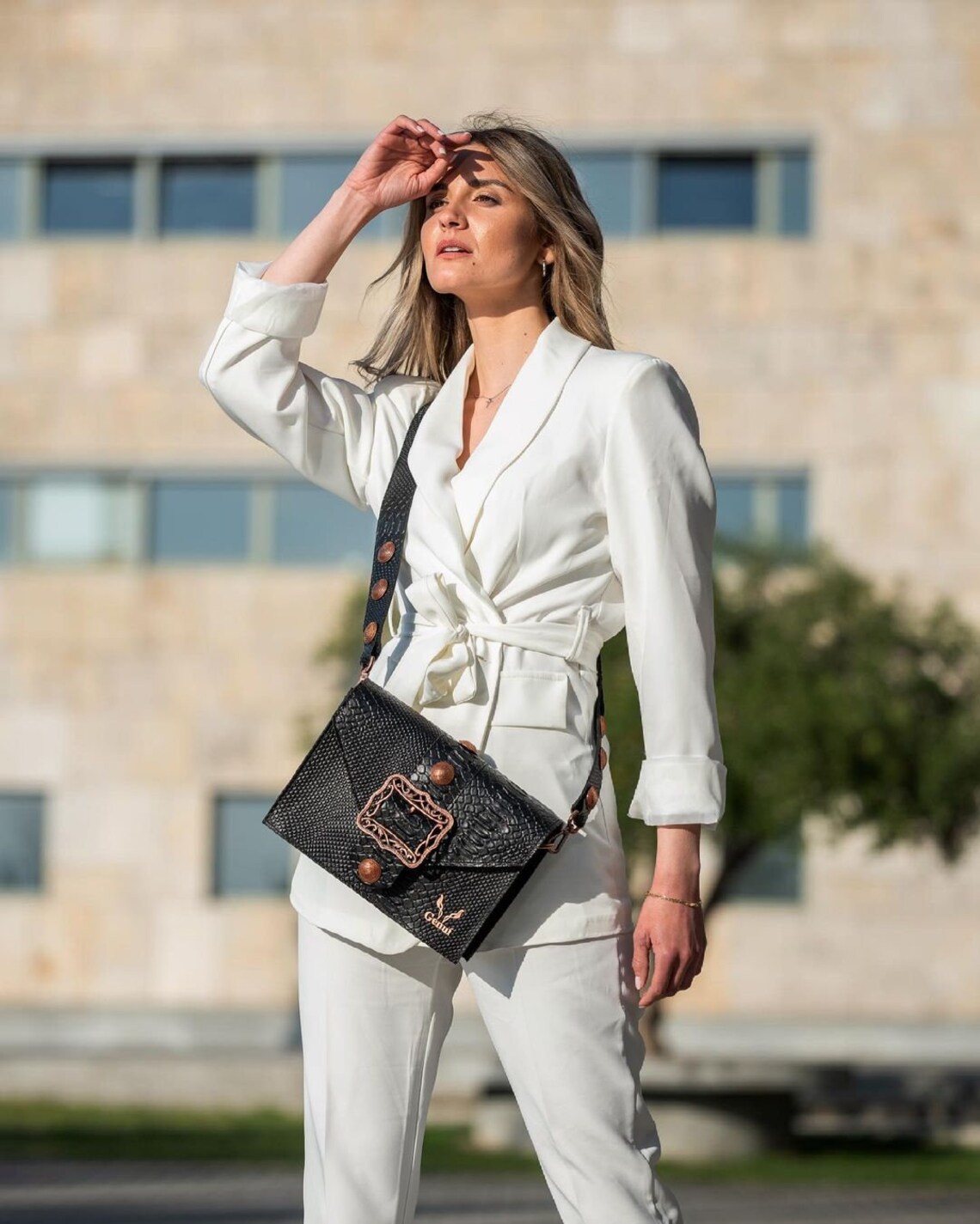 Black leather shoulder bag with a buckle